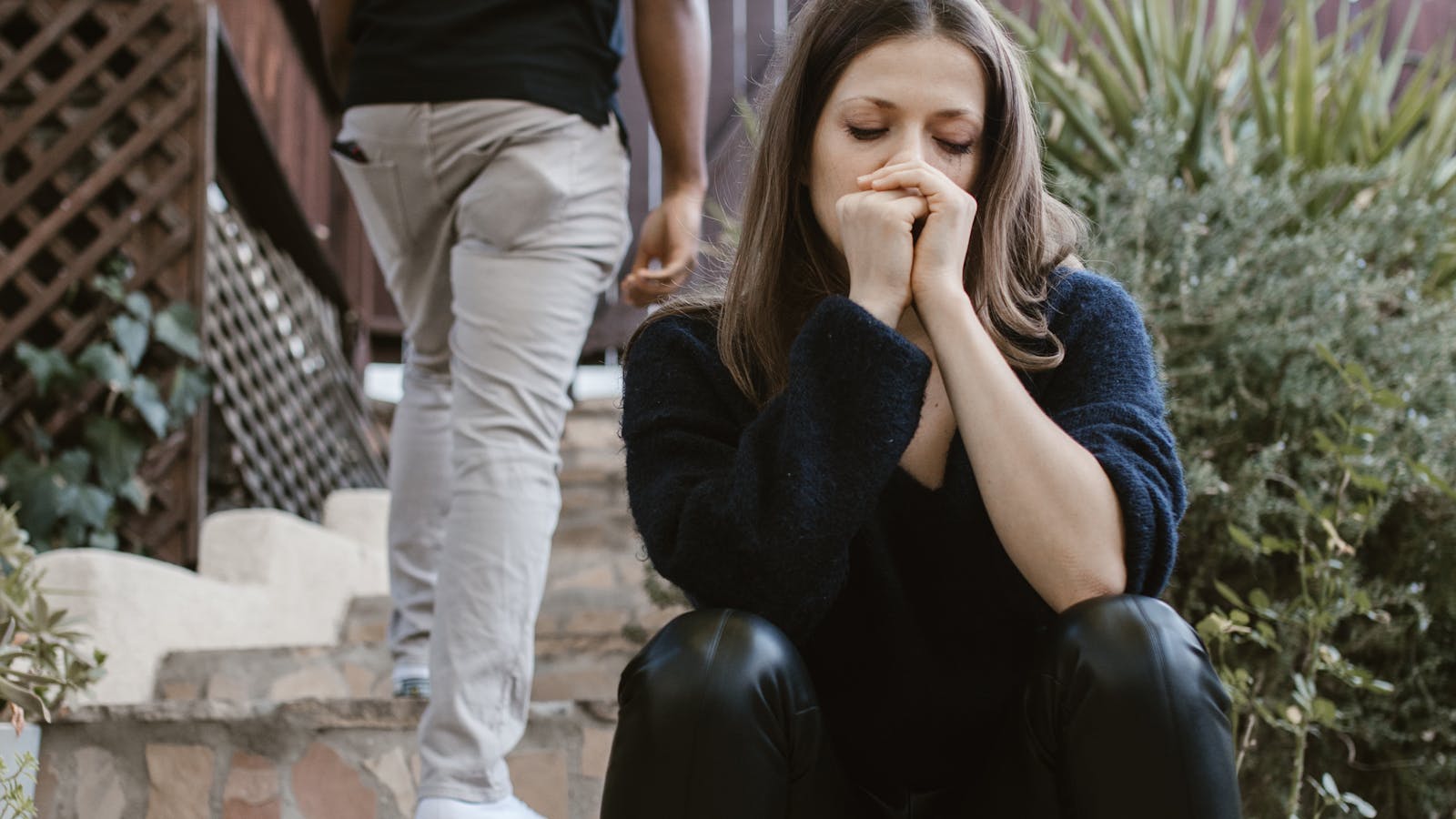 Verdrietige vrouw terwijl een man wegloopt, passend bij scheidingsangst