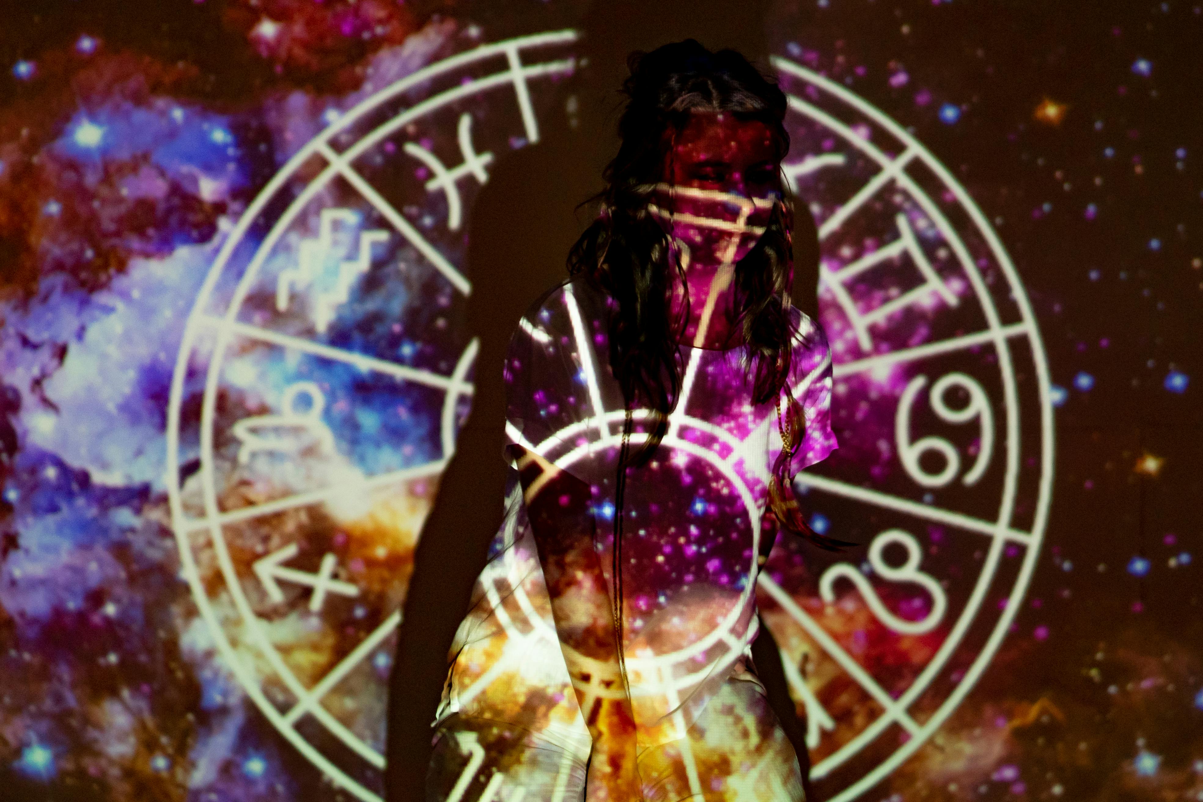 Vrouw met astrologische projectie en sterrenbeeldcirkel, passend bij horoscopen en innerlijke twijfel